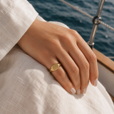Naut & Chain signet ring on model's finger, showcasing a bold metal band with engraved design and classic style.