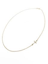 Gold necklace with sideways pave diamond cross pendant by Naut & Chain, showcasing sparkling diamond accents on a sleek chain.